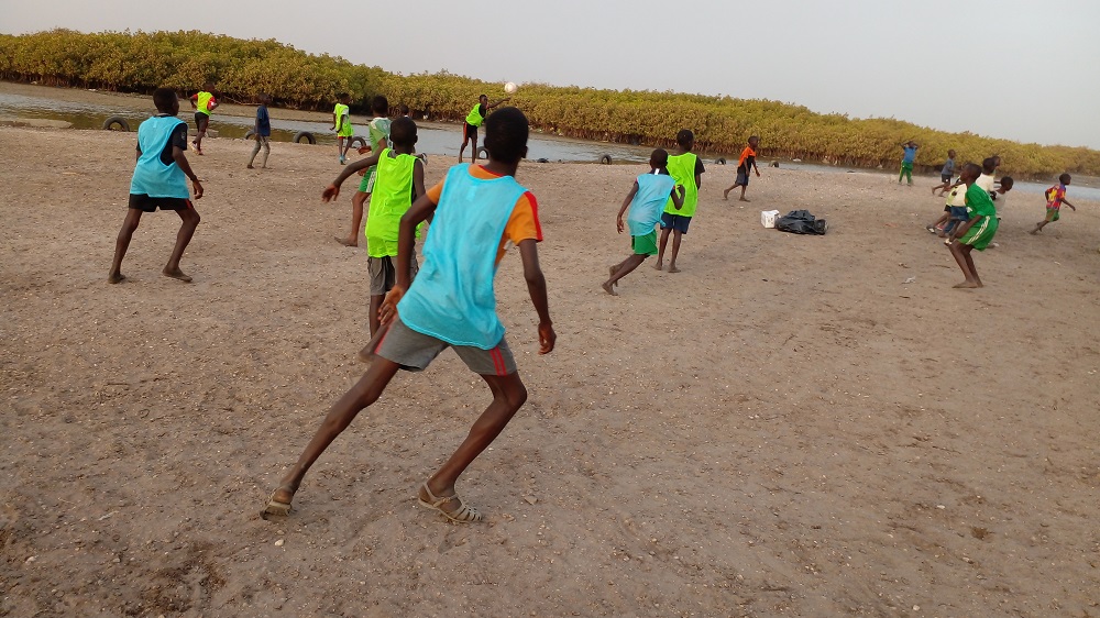 Kinder aus Joal Fadiout/Senegal spielen auf Schotter mit den neuen Bällen